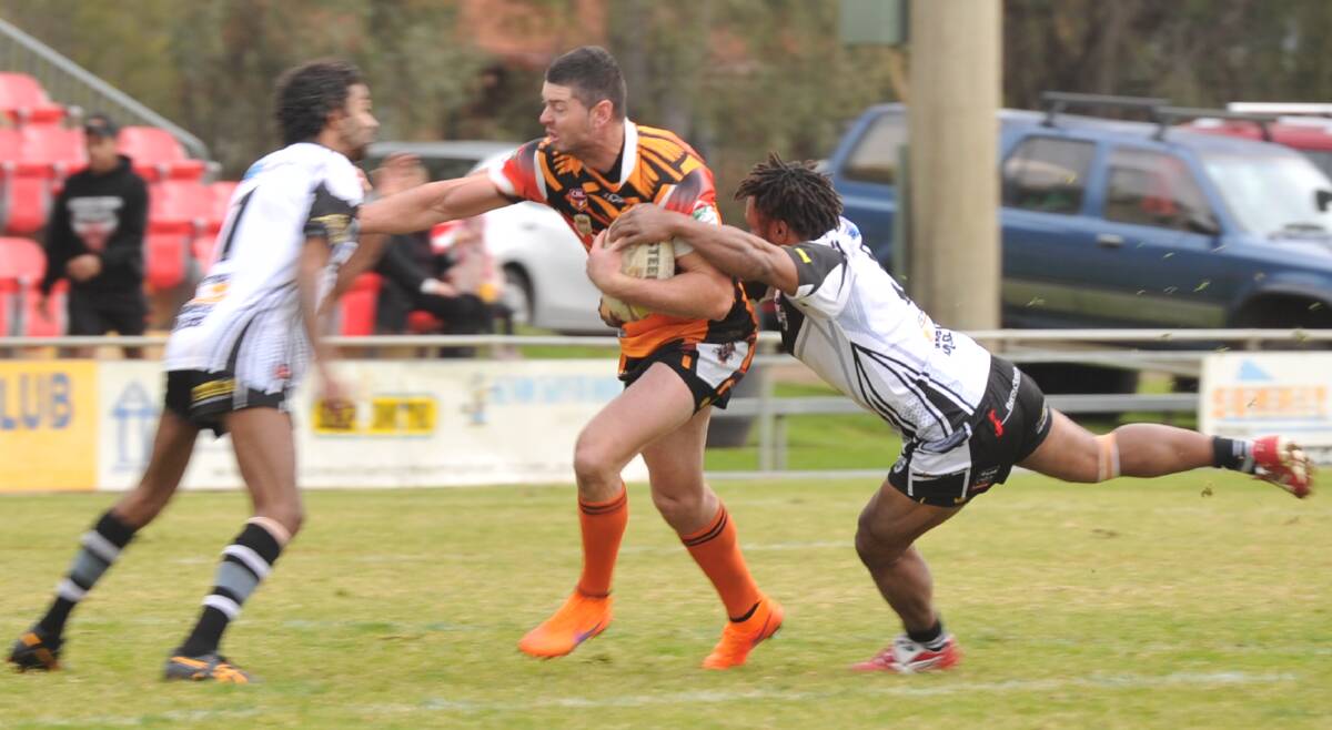 LOOKING FOR A GAP: Waratah Brad Saunders is tackled by Kelvin Simpson and Kevin Frank. Picture: Ben Jaffrey