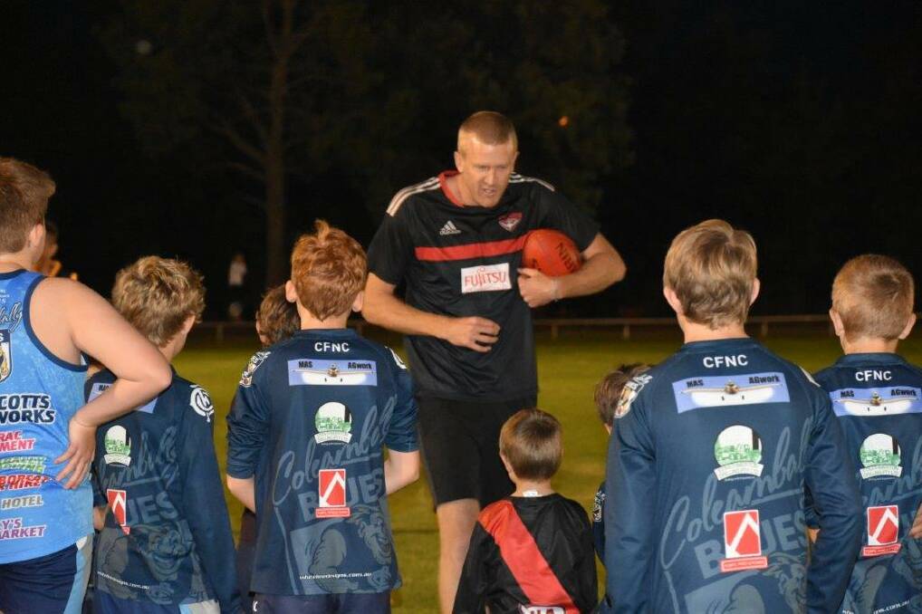 TIPS FOR IMPROVING: Dustin Fletcher passes on his 400 games worth of experience to footballers young and old at Coleambally recently.