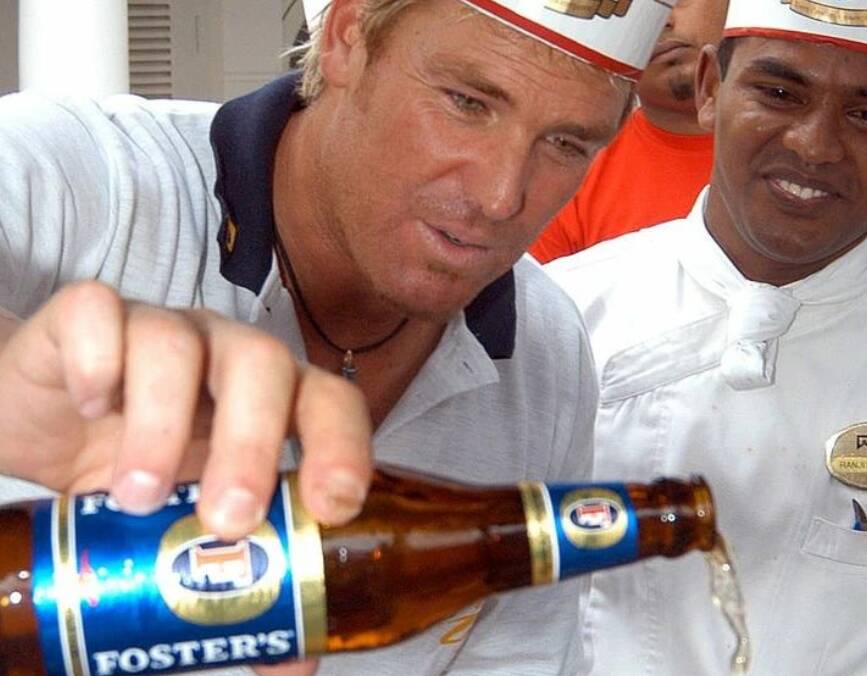 Shane Warne pours a stubbie of Foster's beer. Picture supplied