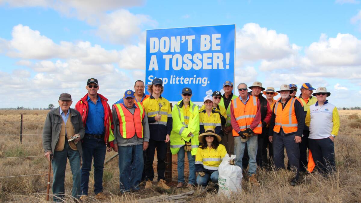 Clean up: members of the Coleambally Lions Club with Coleambally Central School students before a new 'hey tosser' sign on the Kidman Way: PHOTO: contributed 