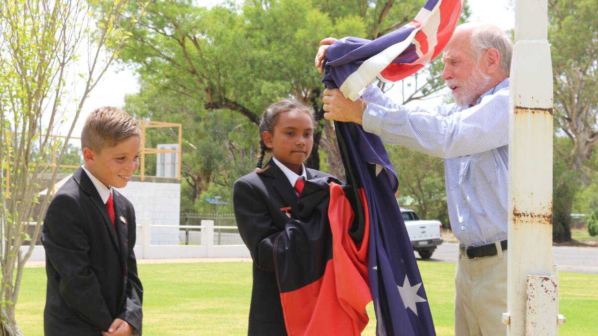 Australia Day: Peter Van Hees raises the two flags with Darlington Point School captains Brock Coe and Mahalia McLean. Picture: Reuben Wylie 