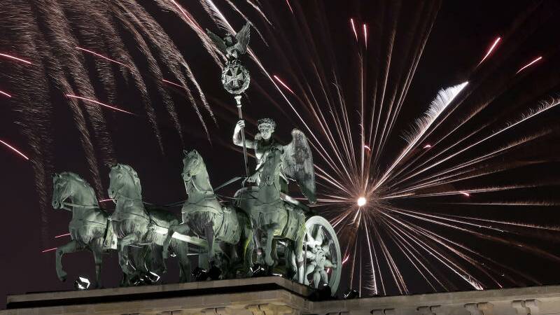 Fireworks light the sky above the Quadriga at the Brandenburg Gate shortly after midnight in Berlin, Germany.