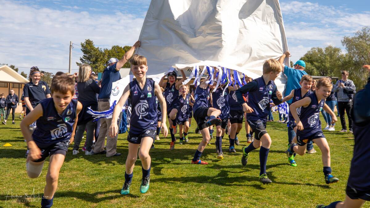 THROUGH THE BANNER: Coleambally Blues under 11s take to the field during the 2019 SWJFNL grand final. PHOTO: Andrew McLean