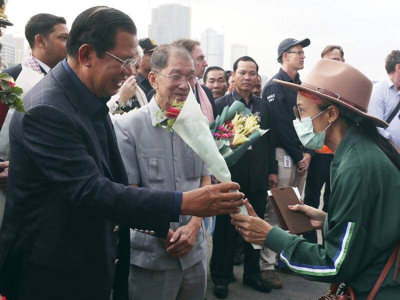 Cambodian PM Hun Sen gives flowers to a passenger off the cruise liner Westerdam at Sihanoukville.
