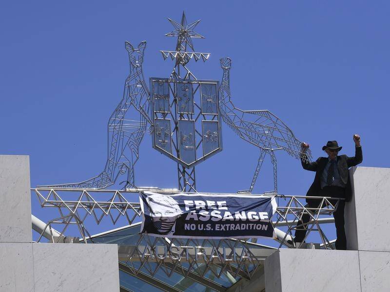 A man who scaled parliament house to demand the release of Julian Assange has been arrested.